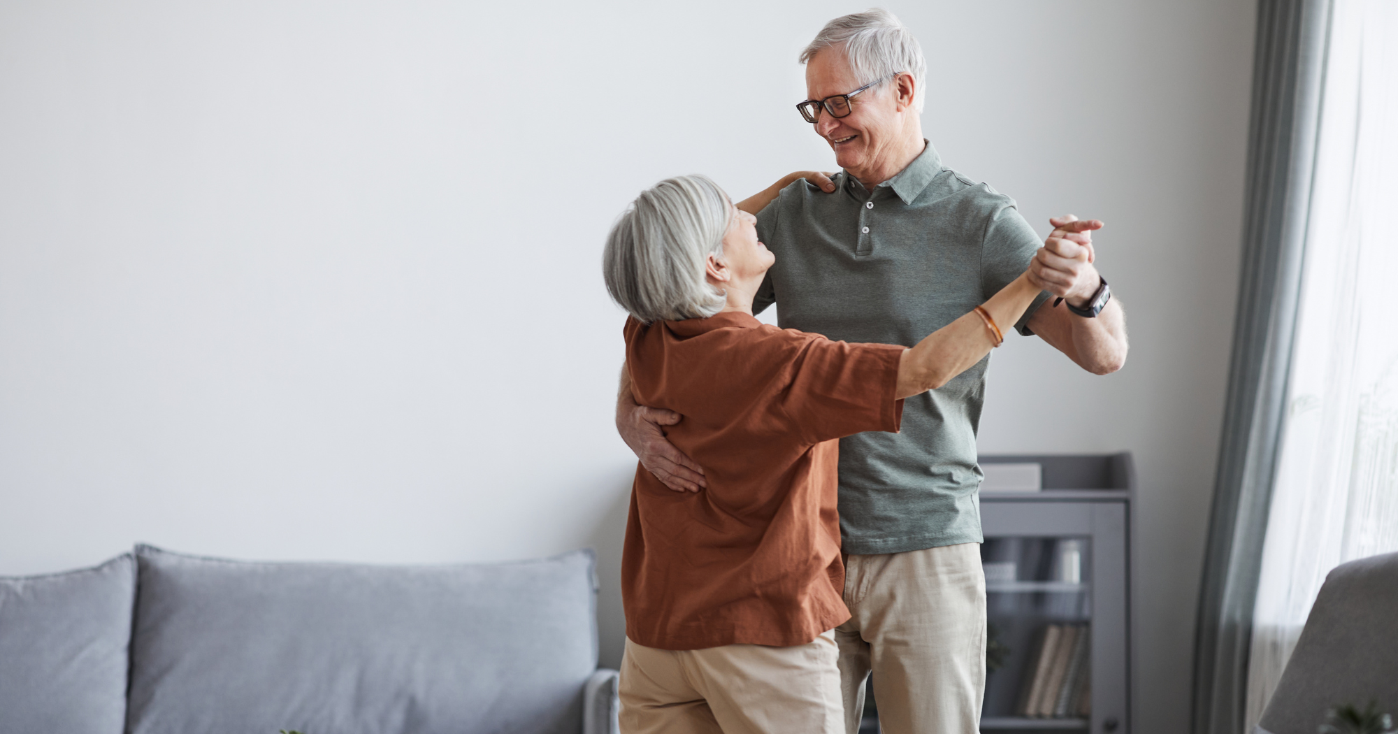 An elderly couple dancing in their home