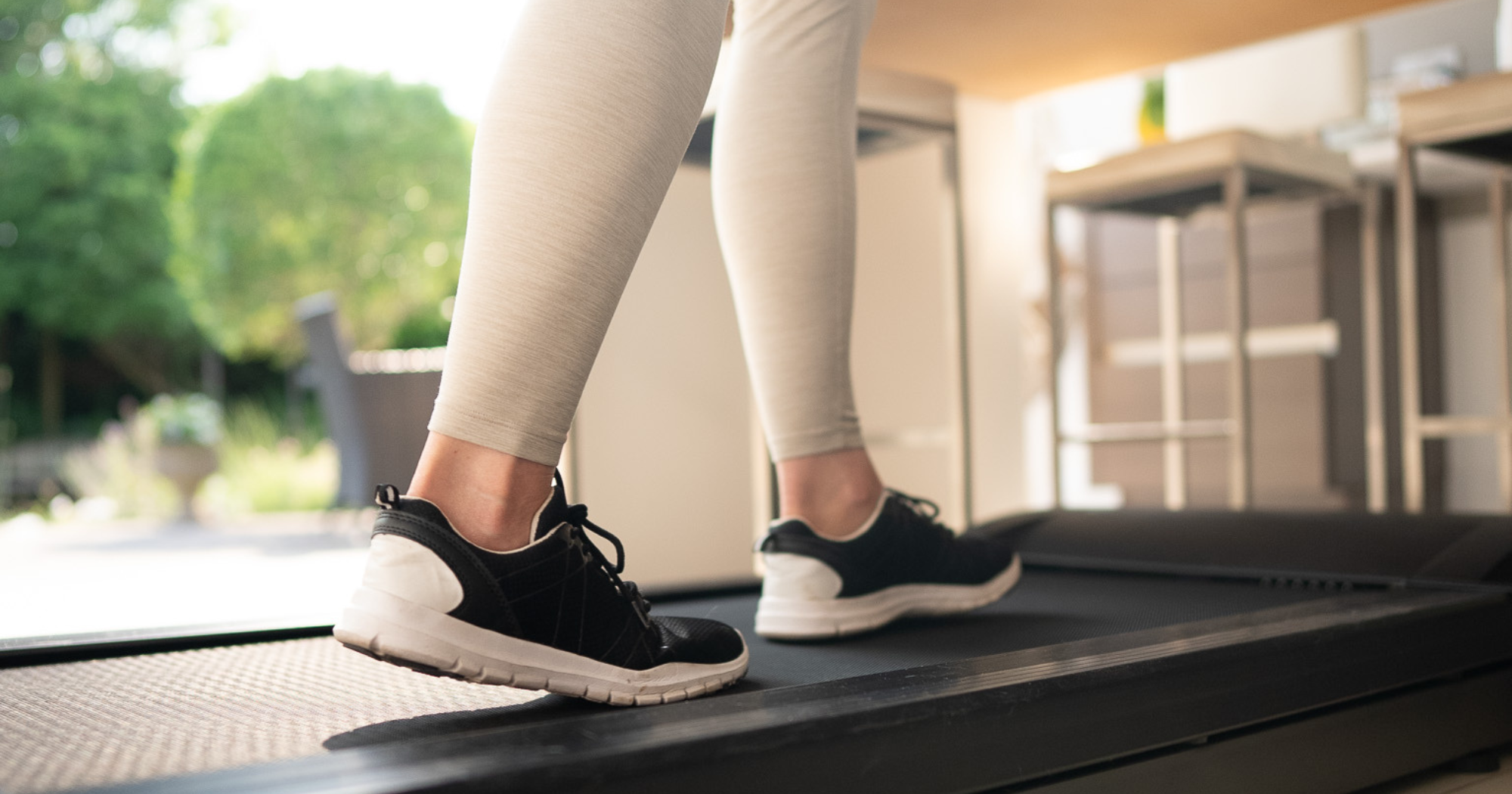 Can a Walking Pad Help You Lose Weight? A woman using a walking pad in her home.