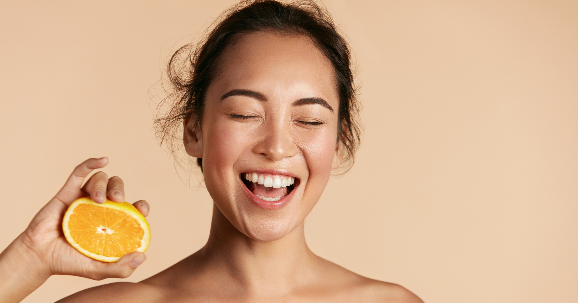 a person holding an orange in front of their face