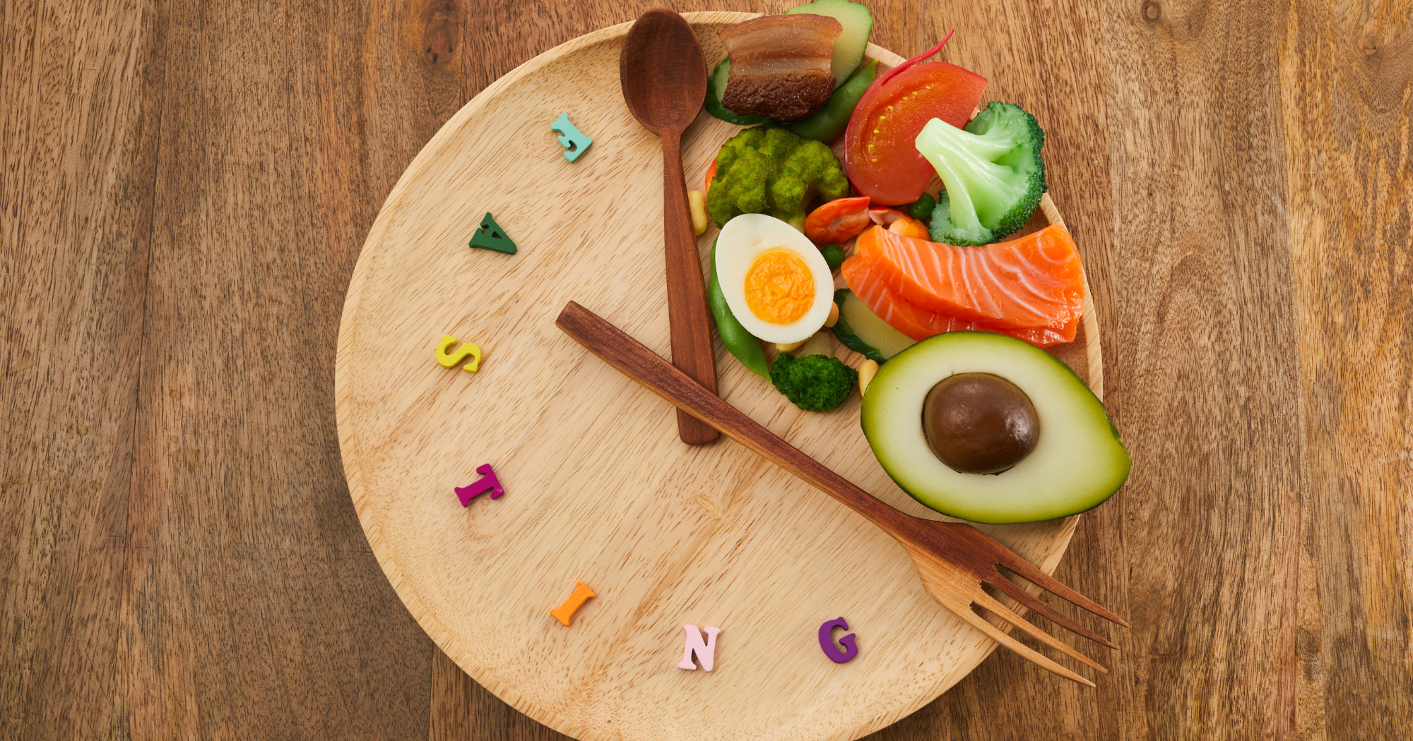 a wooden plate that uses cutlery to look like a clock with food placed in a specific 'time frame'