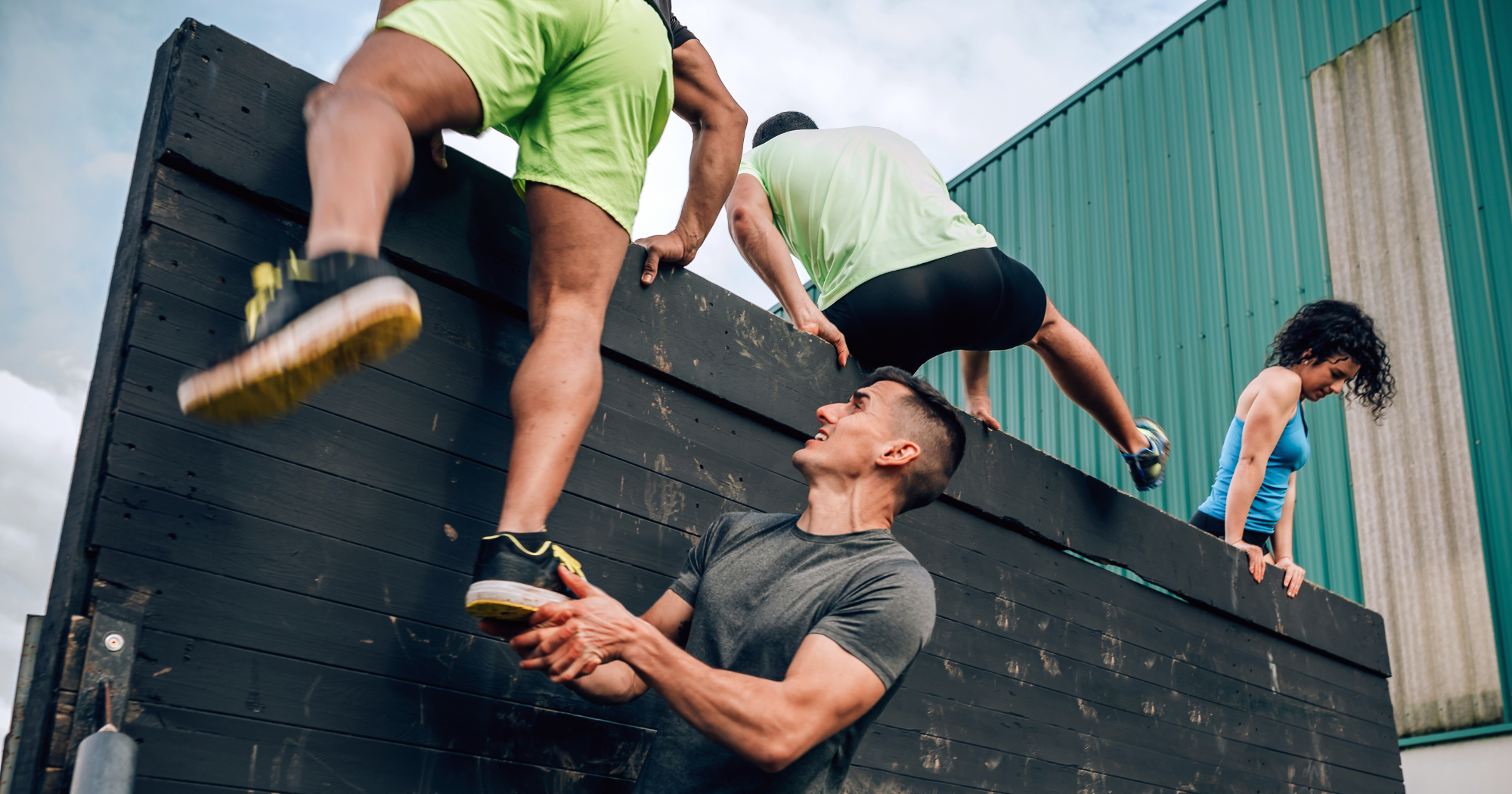 a group of people climbing over a wall