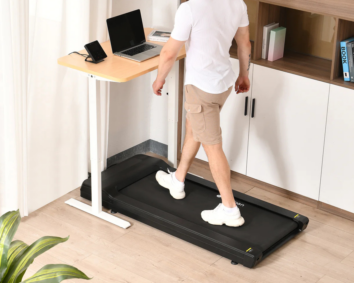 Man on a walking pad at a standing desk